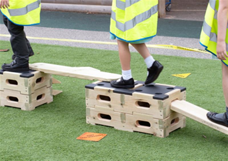 Zoomed in image of three children directing each other across the Play Builder trail, developing their natural leadership skills.